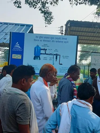 A group of farmers in Barwani, Indore, gathered around our informational display board, learning about the components of an ideal micro-irrigation head unit.