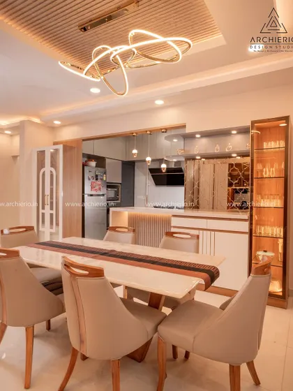 A beautifully lit dining area with a modern ring chandelier and a custom crockery unit, creating an elegant space for family meals.
