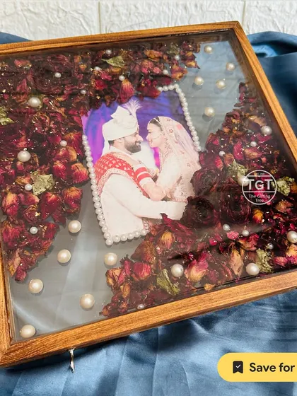 The deep red of the preserved rose petals looks stunning against the dark teakwood, creating a rich and romantic keepsake.