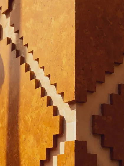This is a close-up of the modular facade at Stone Print Villa. What appears as a simple stepped pattern from afar is a system of precisely calibrated CNC-cut panels made from a stone-resin composite. It's a way we use technology to articulate form and create rhythmic, textured surfaces.