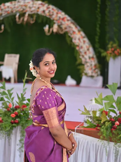 A happy client in a purple silk saree with a custom puff-sleeve blouse. Her smile is a testament to feeling comfortable and beautiful.