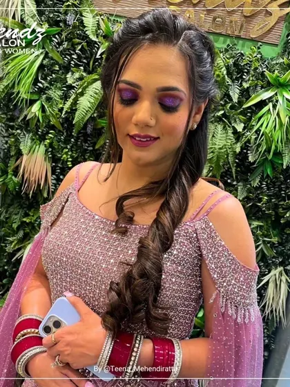 The complete look, showcasing the bold eye makeup and intricate hairstyle. The client is wearing a sparkling pink outfit, and the makeup complements it perfectly for a festive celebration.