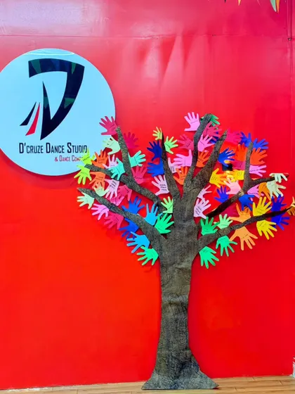 A close up of our appreciation tree against the studio's red wall, with our D'cruze logo proudly displayed. It's a colorful reminder of all the kids who joined us.