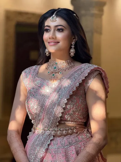 A beautiful shot of the bride in her pink reception lehenga, the soft light creating a radiant glow around her.