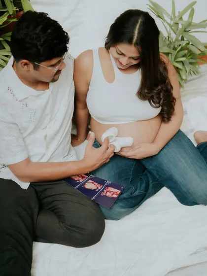 An intimate lifestyle session capturing the couple looking at their baby's first shoes together. These quiet, at-home moments are incredibly precious.