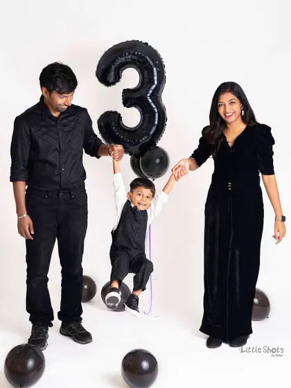 A playful family portrait celebrating a third birthday. The parents swinging their happy son is a perfect picture of family joy and togetherness.