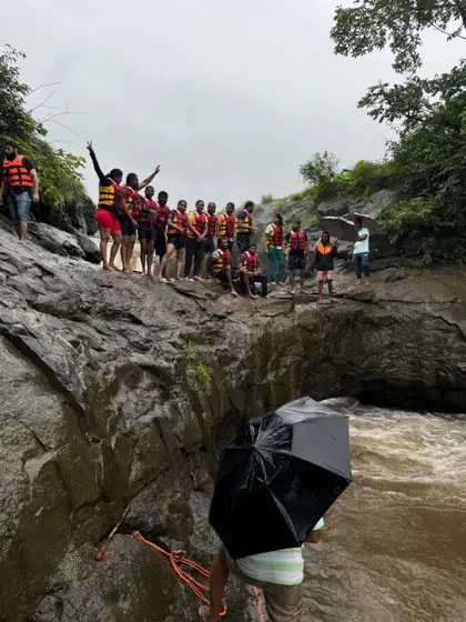It's a wrap! A group photo after a thrilling waterfall rappelling session. Safety gear on, and smiles all around.