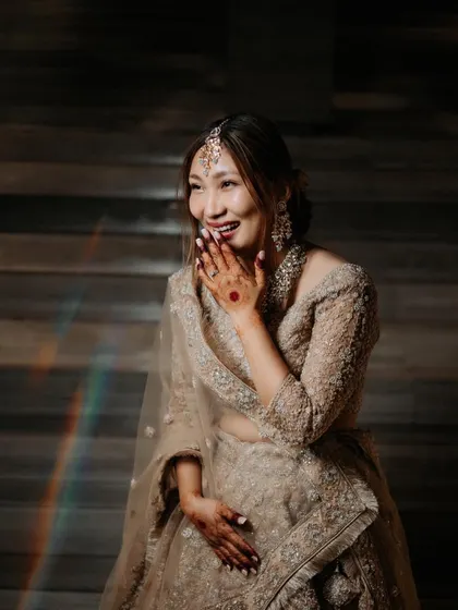 A joyful, candid portrait of the bride Asen from Nagaland, her happy expression captured with a beautiful rainbow light flare.