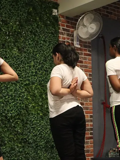 Students practice Paschima Namaskarasana (Reverse Prayer Pose), a great shoulder opener that improves posture.