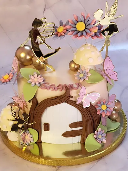 An enchanted forest themed cake, complete with a fairy house, magical mushrooms, and delicate fairy toppers. This design is perfect for a whimsical birthday party.