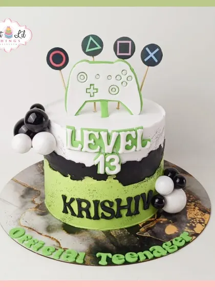 Level 13 unlocked! A cool PlayStation-themed cake for an official teenager, featuring a game controller and the iconic button symbols.
