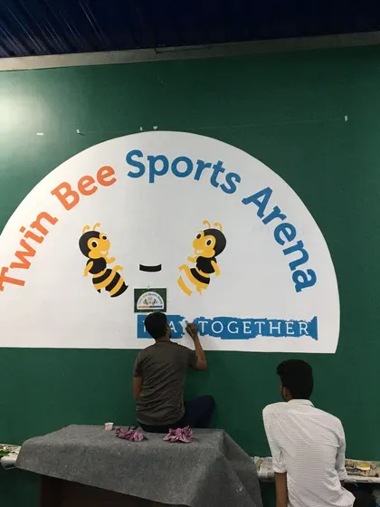 A behind-the-scenes look at our team painting the 'Twin Bee Sports Arena' logo. We work on-site to bring our client's vision directly onto their walls.