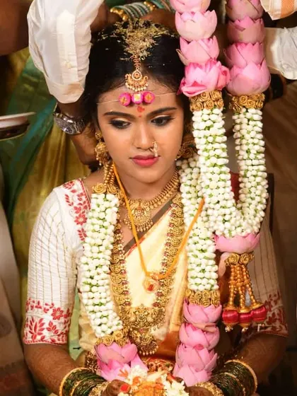 This bride is adorned with beautiful floral garlands for her ceremony. Her makeup is kept classic and radiant, with a focus on her eyes and a soft lip color to balance the look.