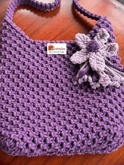 A beautiful purple shoulder bag with a two-tone flower accent. I love how the simple design lets the color shine.