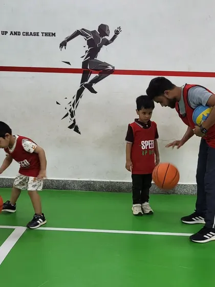 A coach provides one-on-one instruction on dribbling. This personalized attention helps kids grasp the technique correctly and build confidence.