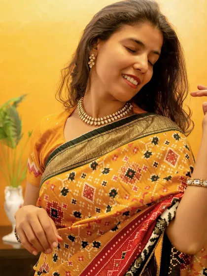A joyful, expressive portrait in a vibrant yellow saree, conveying a festive and celebratory mood.