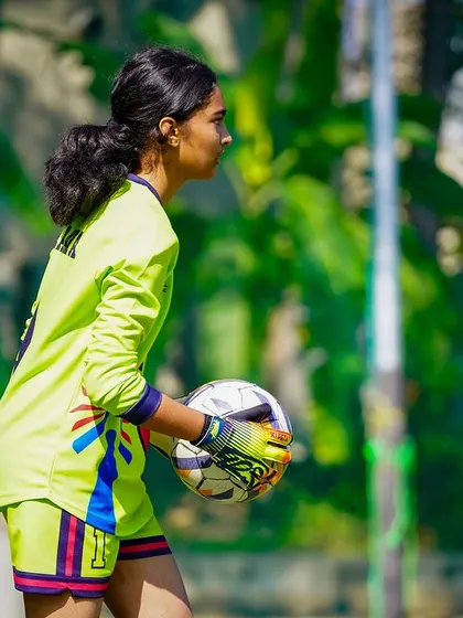 Our goalkeeper, focused and ready, prepares to distribute the ball and start an attack for her team.