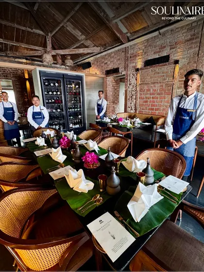 Our service team stands ready at the 'Forest to Feast' event, with tables set with banana leaves and rustic decor. We are committed to delivering authentic and meaningful dining experiences.