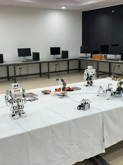 A look inside one of our labs, with various types of robots, including humanoid and spider-bots, displayed on a table, ready for students to explore.