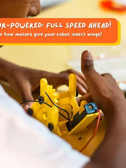 A student connects the battery pack to their insect bot, completing the circuit. This is a key moment where they see how motors are powered to bring their robot to life.