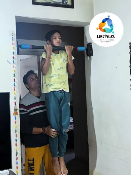 Providing a gentle lift to help a young client with his pull-up. This supportive coaching helps kids achieve their goals and build self-esteem.
