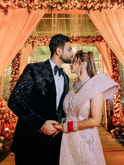 A tender forehead kiss, capturing a quiet, romantic moment amidst the grand reception.
