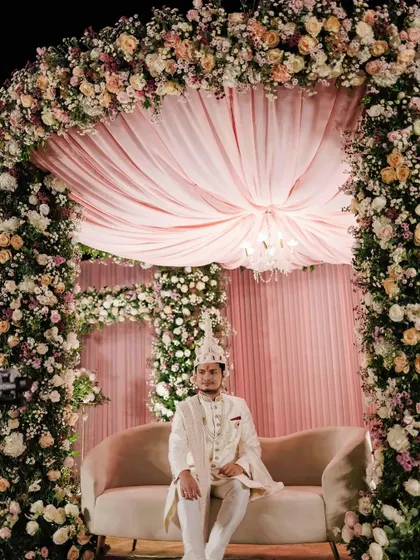 For Sakshi and Shuvam's wedding, we created this opulent mandap under the stars. The structure was completely covered in lush pink, peach, and white florals, with a soft fabric canopy and a chandelier for a touch of timeless elegance.