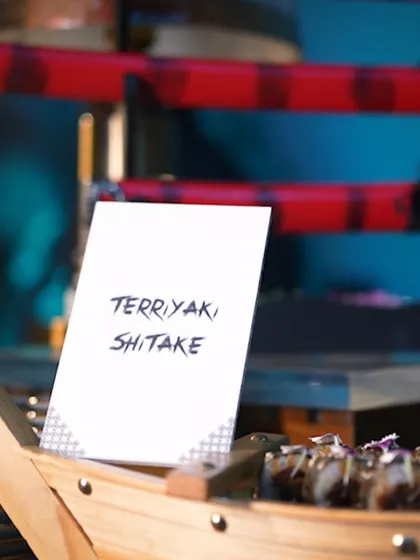 A menu card for "Terriyaki Shiitake," hinting at the delicious Japanese-inspired canapés being served. Clear and elegant labelling is a key part of our service.