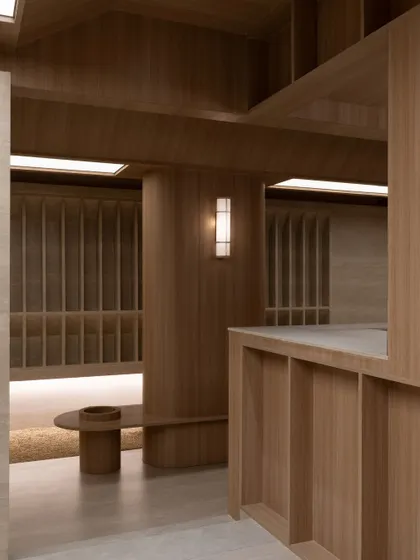 Another perspective of the interior at Be Well, highlighting the interplay of volumes and surfaces. The design avoids ornamentation, focusing instead on the inherent beauty of the wood and stone.