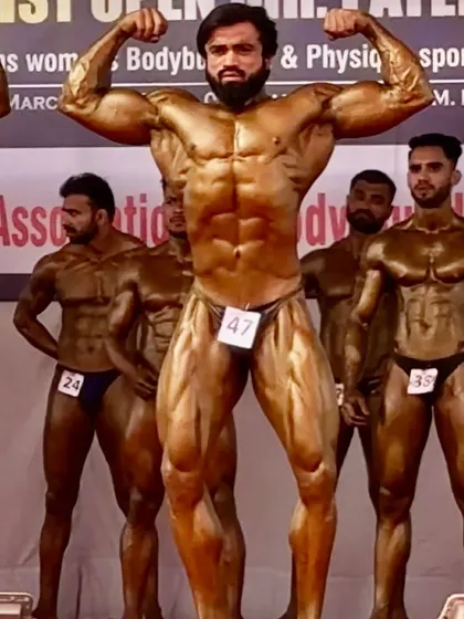 A powerful front double biceps pose on stage. This is what it looks like to be fully prepared to compete against the best.