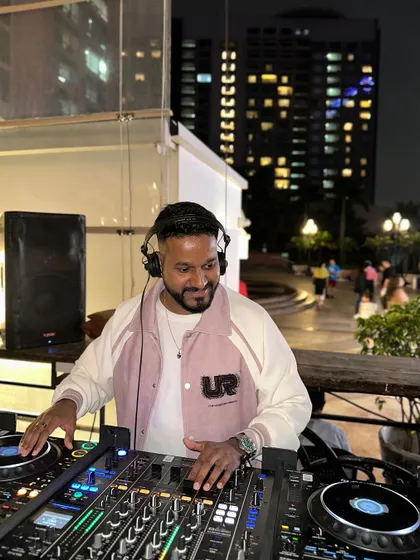 Mixing at an outdoor venue with city lights in the background.
