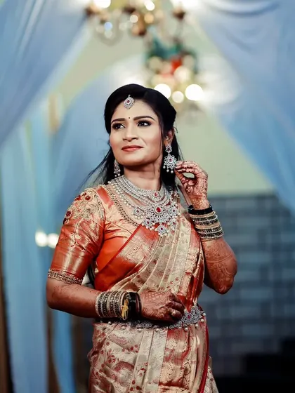 A bride looking regal in a full American diamond and ruby jewellery set for her reception. The set includes a statement choker, layered necklace, and matching vaddanam.