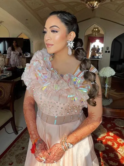 The bride looks absolutely radiant and ready for her Mehendi celebration with this unique hairstyle.