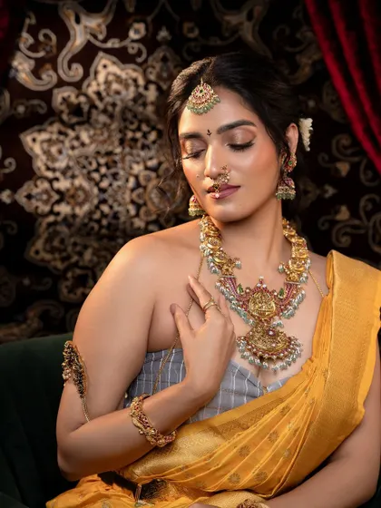 A close-up of the bride in a seated position, giving a clear view of the necklace, vanki, and bracelets.