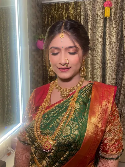 The eye makeup for this Puja look is soft and shimmery, designed to catch the light beautifully. It enhances her eyes without being too heavy.