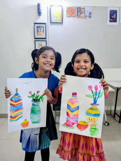 Aradhya and Usra from our junior batch with their colorful still life paintings of vases. Their bright smiles match their vibrant artwork.