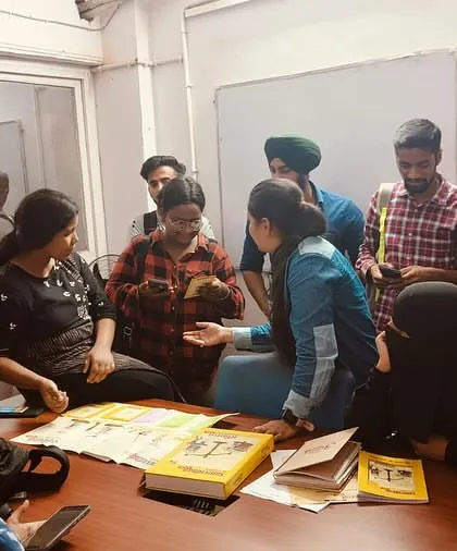 Participants huddle together to work on a group task. These collaborative exercises are designed to build teamwork and problem-solving skills while learning about civic duties.