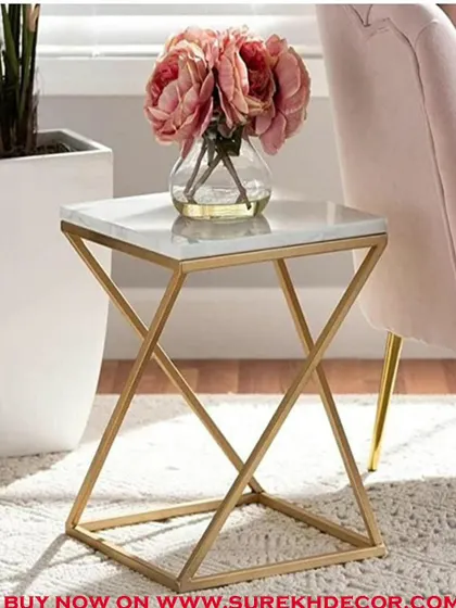A chic and modern side table with a white marble top and a rigid, geometric golden base. This piece is perfect for adding a touch of glamour next to a sofa or armchair, providing a stylish surface for a lamp or decor.