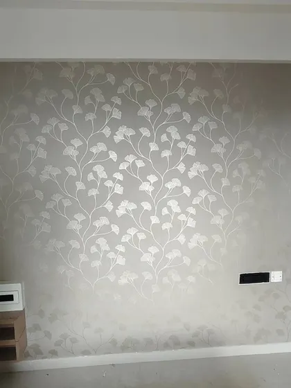 A subtle and elegant silver-grey wallpaper with a delicate ginkgo leaf pattern. This type of metallic-finish paper requires careful handling to avoid marks and ensure a flawless look.