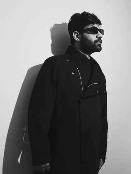 A strong, graphic black and white portrait. The sharp lines and shadows reflect the precise, clean sound of minimal techno.