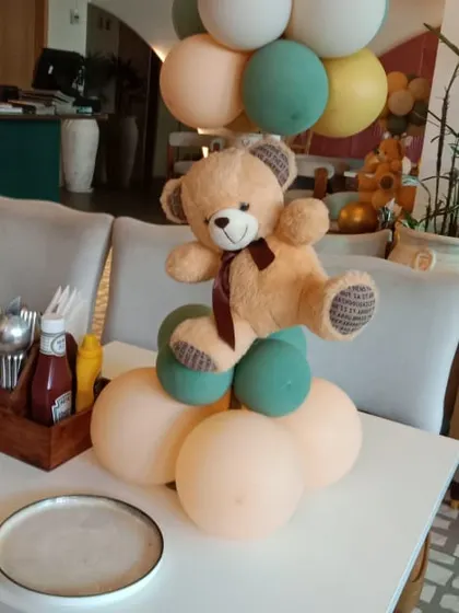 A simple yet charming table centerpiece for a teddy bear themed party. I create these small balloon arrangements with a teddy bear on top to decorate guest tables and complement the main decor.