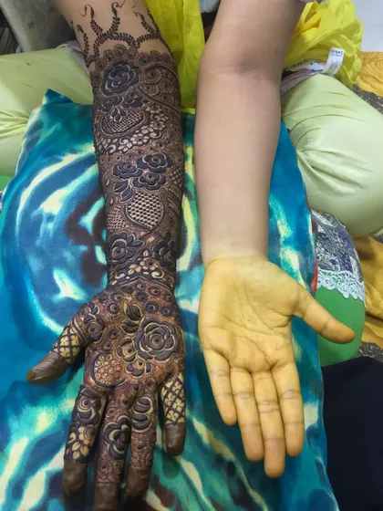 Before and after! One arm is completely adorned with a full bridal design, while the other is ready for its turn.