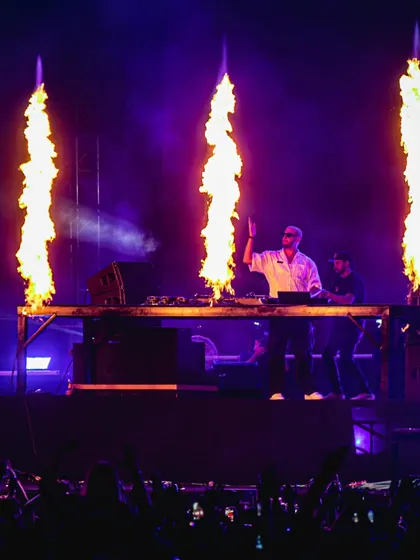 DJ Snake commands the stage with three massive jets of fire erupting in front of him.
