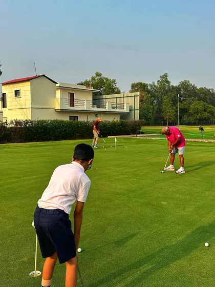 A junior golfer lines up a putt on our practice green. We focus on teaching the fundamentals of every part of the game, including the short game.