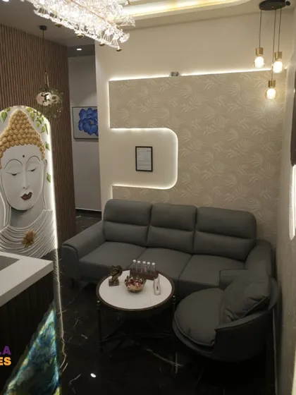 The waiting lounge of the spa features a comfortable L-shaped sofa and a custom Buddha art installation. We used recessed and layered lighting to create a soft, inviting ambiance where guests can relax before their treatments.
