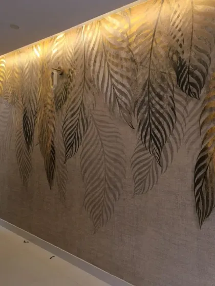 A full view of a wall with a cascading golden feather mural. The metallic sheen on the feathers catches the light beautifully.