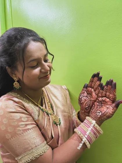 A happy bride-to-be admiring her intricate mehendi. Seeing this joy on my clients' faces is the best part of my job as a kalakaar.