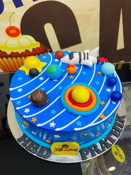 A 1.5kg solar system cake with planets orbiting the sun, perfect for a young astronomer.