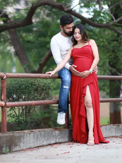 An outdoor maternity session offers a completely different vibe. We used the soft, natural light of a park in Navi Mumbai to capture this relaxed and romantic portrait. The vibrant red dress against the greenery creates a beautiful, timeless image.