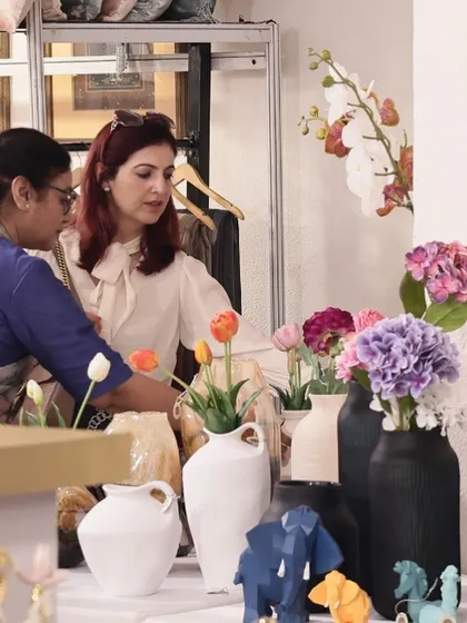 A client selecting from a beautiful array of vases and floral arrangements at my exhibition. I strive to offer decor that brings life and color into any space, and moments like this confirm I am on the right path.